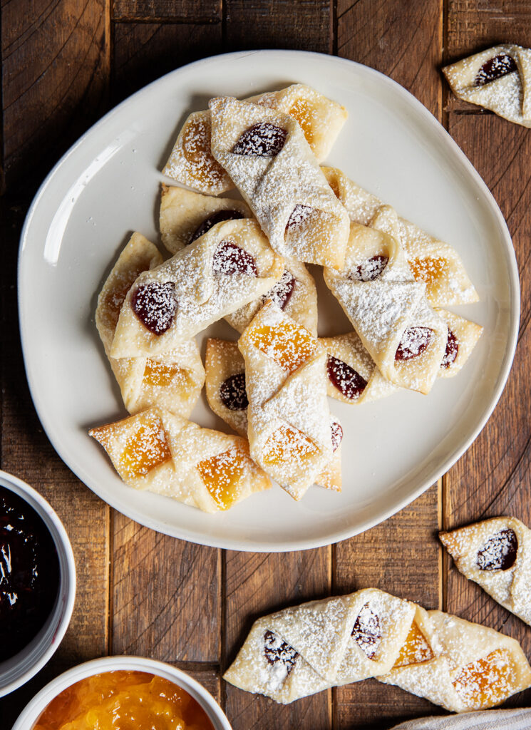 An above view of a plate of kolacky cookies filled with raspberry and apricot jam.