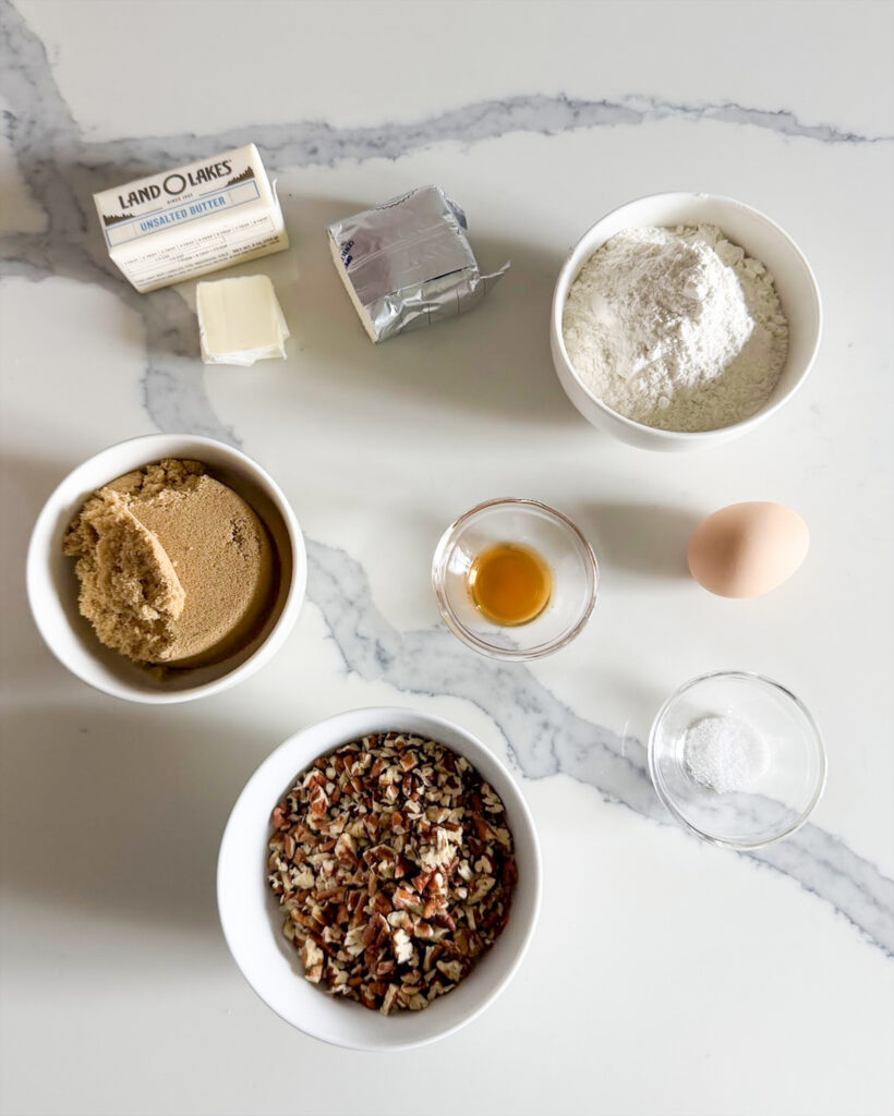 The ingredients needed to make pecan tassies on a white counter top. 