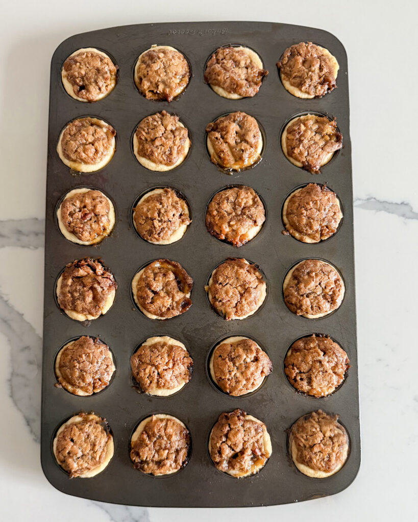 Baked pecan tassies in a mini muffin pan.
