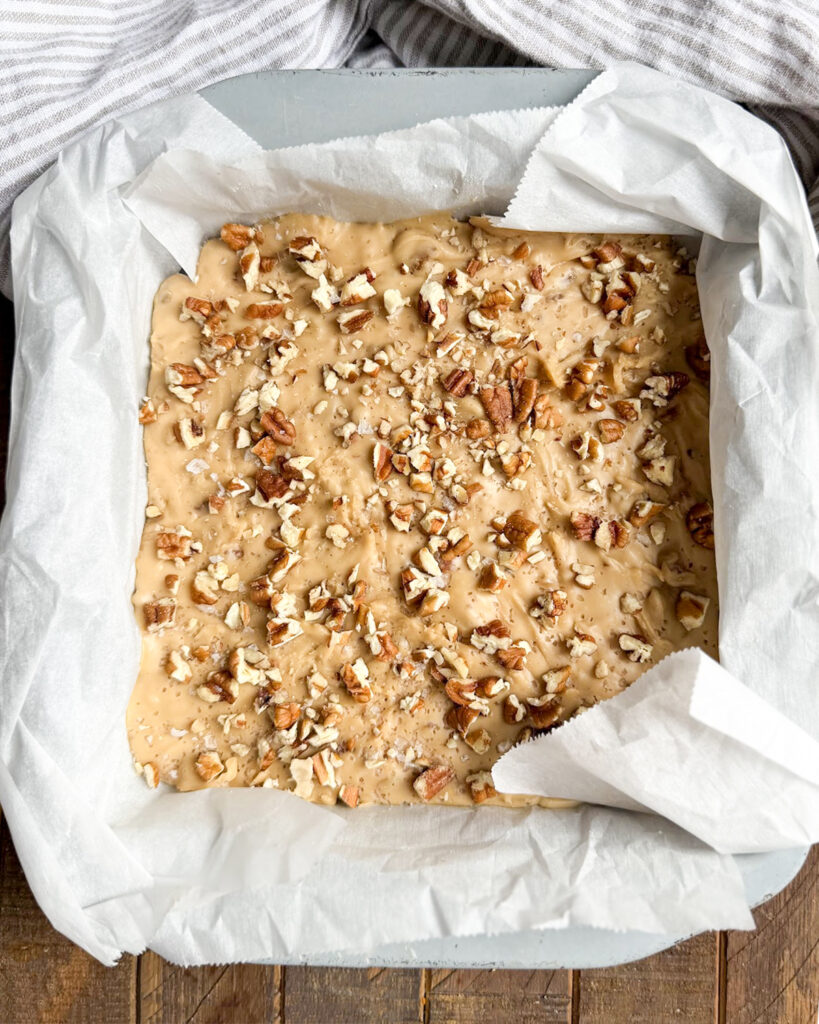 An above view of a pan of penuche fudge topped with pecans.