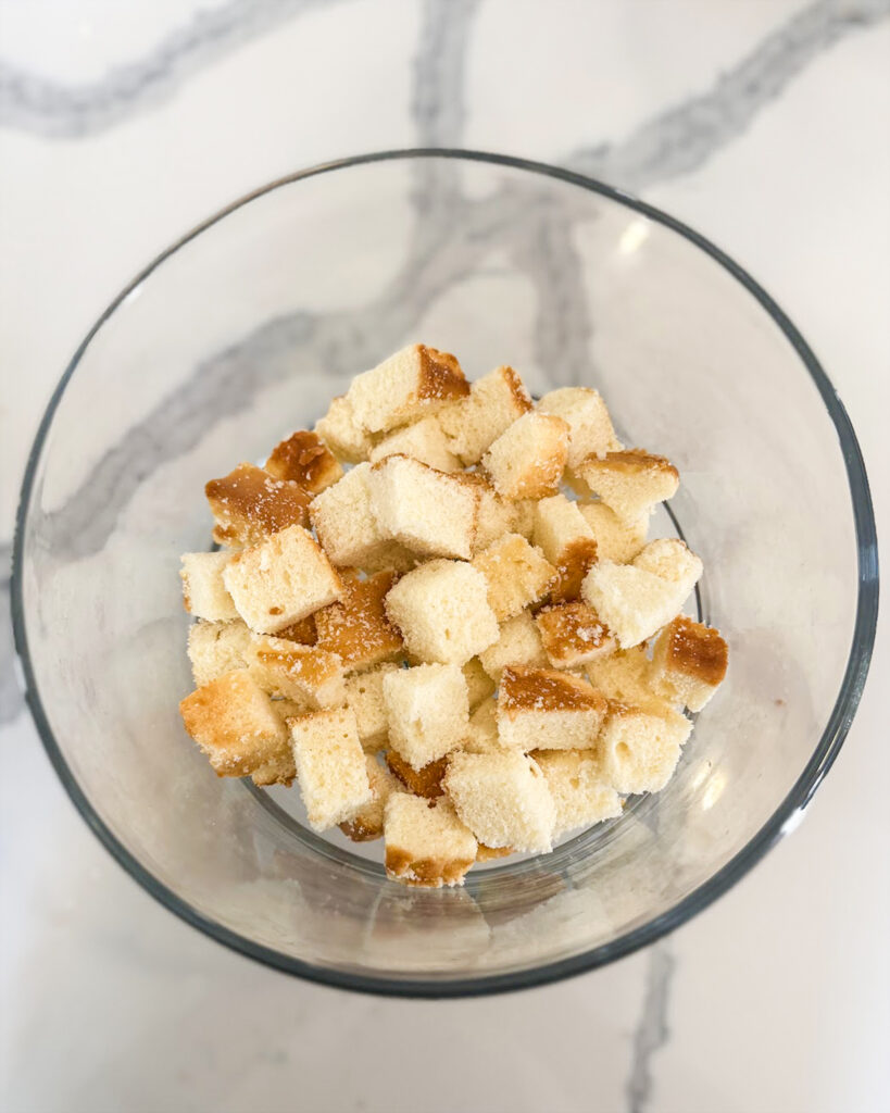 A glass bowl with cubes of pound cake.