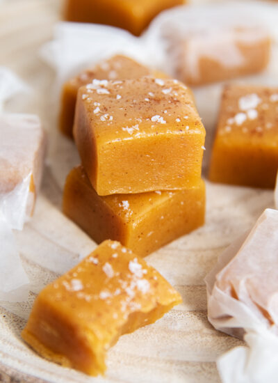 A stack of two pumpkin caramels topped with cinnamon and sea salt.