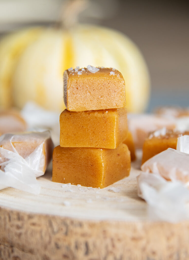 A stack of three pumpkin spice caramels topped with sea salt.