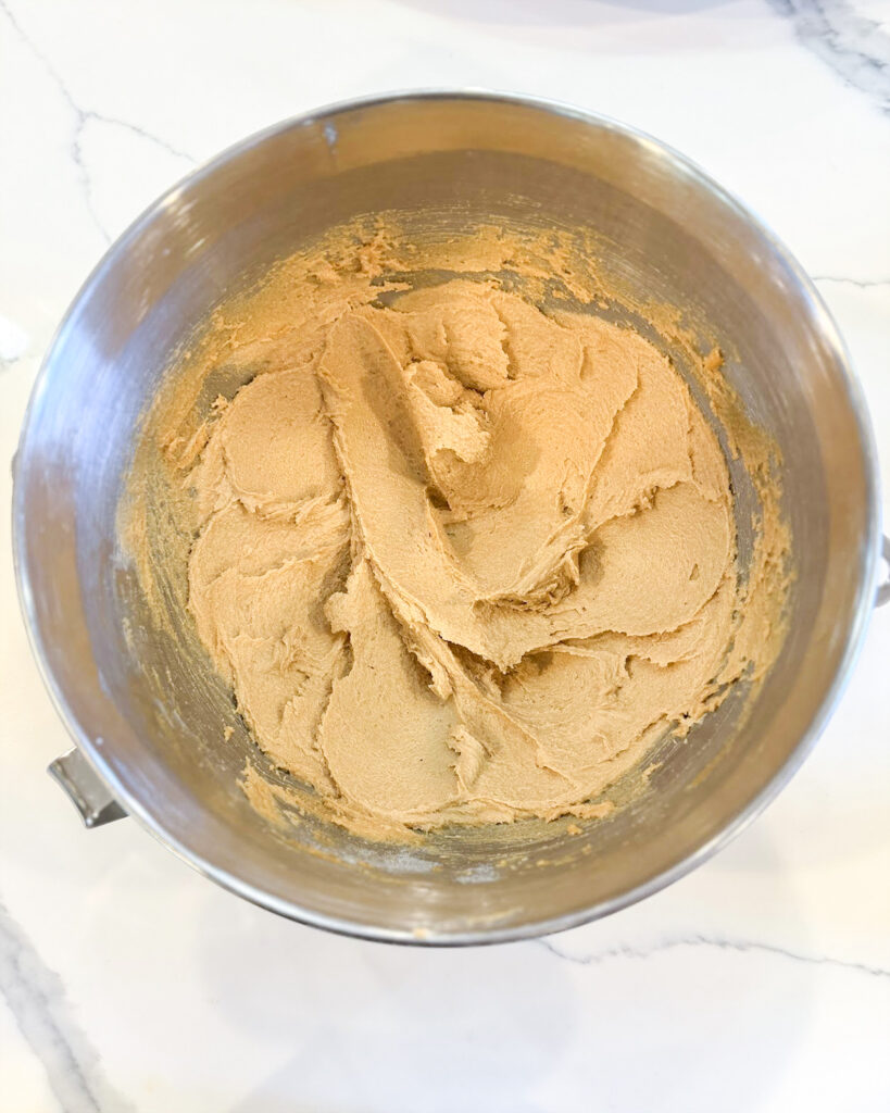 Creamed together butter, peanut butter, and sugars in a metal bowl.