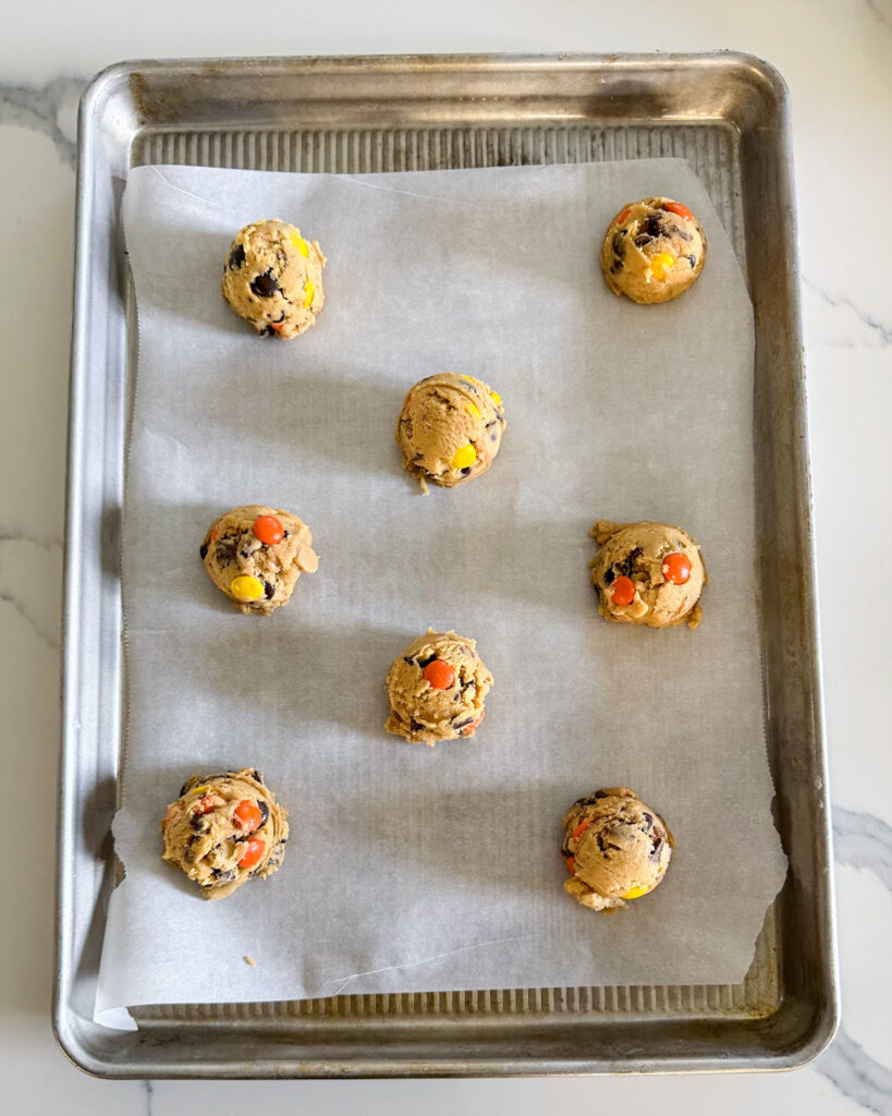 Cookie dough balls on a cookie sheet.