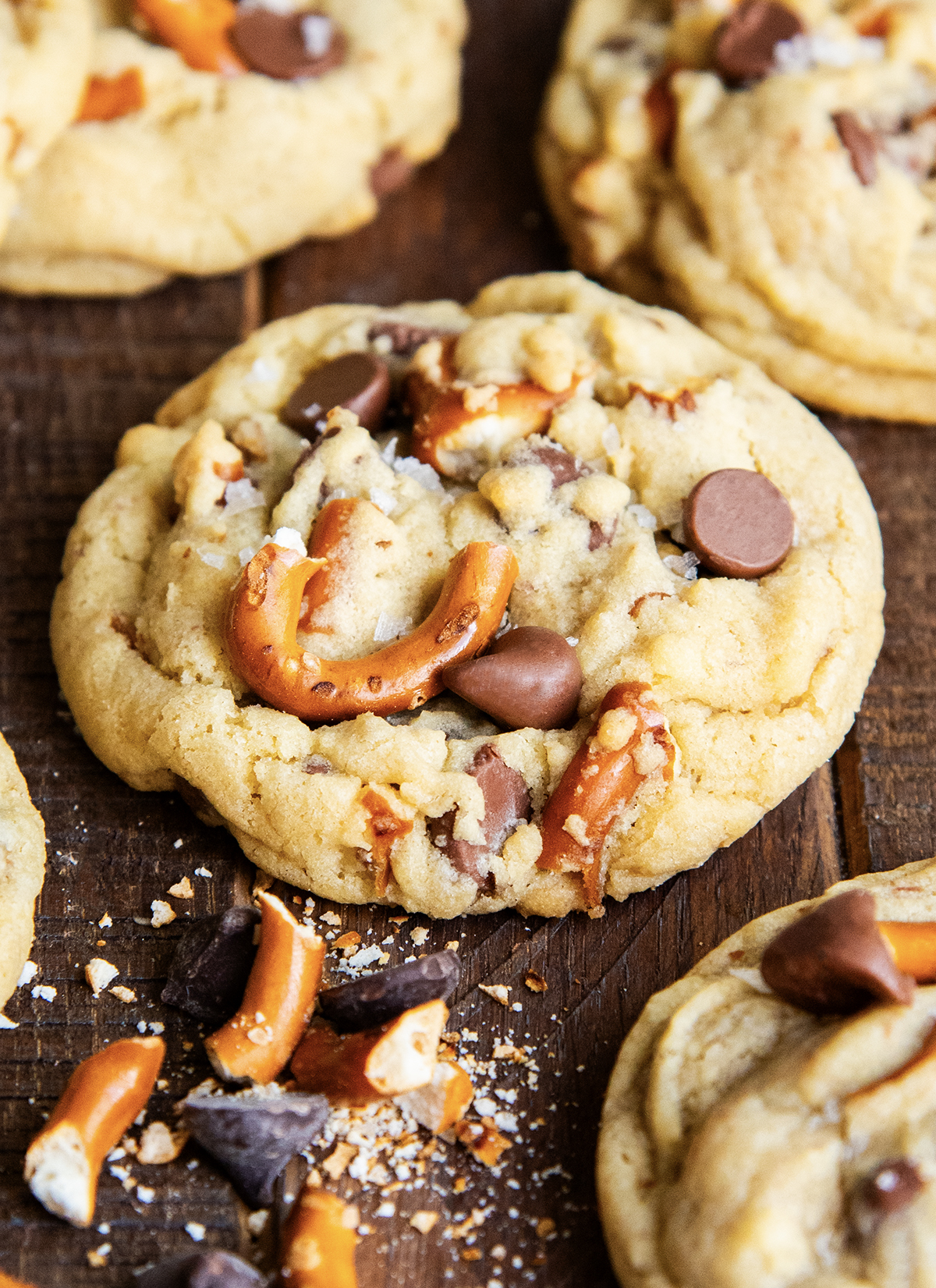 A chocolate chip cookie with pieces of pretzels and flakey salt on top.